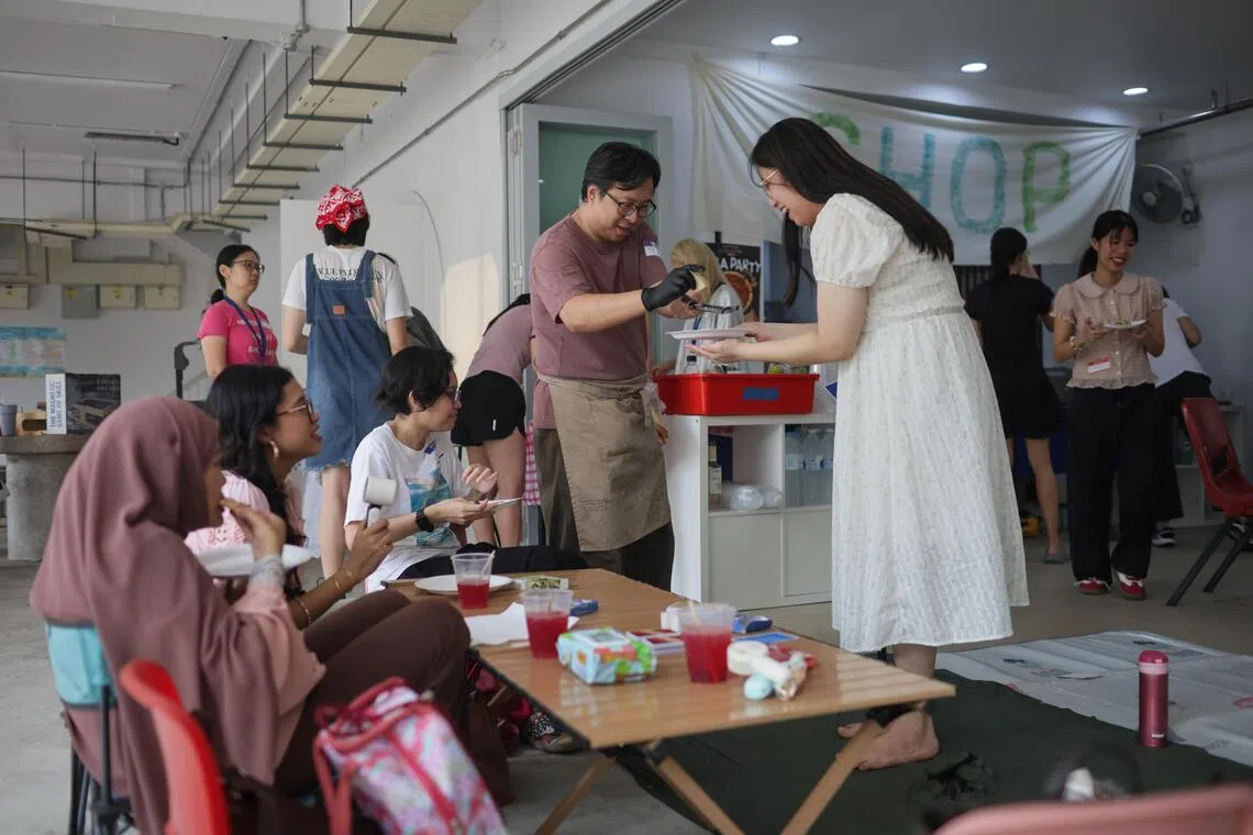 Volunteer Solomon Kang, 47, grates cheese for a participant at the sixth edition of Kampung Soup Kitchen, a pizza party at The Chop Community held at 287 Yishun Ave 6.