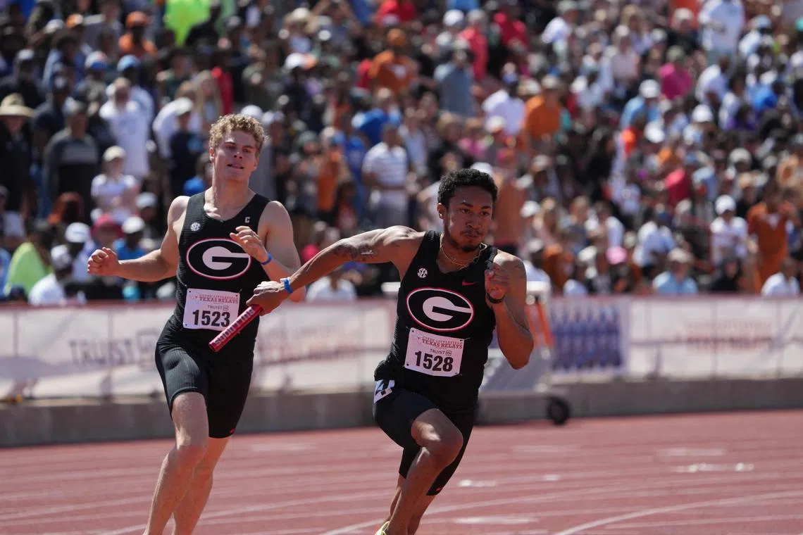 FILE PHOTO: Apr 1, 2023; Austin, TX, USA; Christopher Morales-Williams takes the handoff from Matthew Boling on the third leg of the Georgia Bulldogs 4 x 200m relay that won in a meet record 1:20.22 during the 95th Clyde Littlefield Texas Relays at Mike A. Myers Stadium. Mandatory Credit: Kirby Lee-USA TODAY Sports/File photo