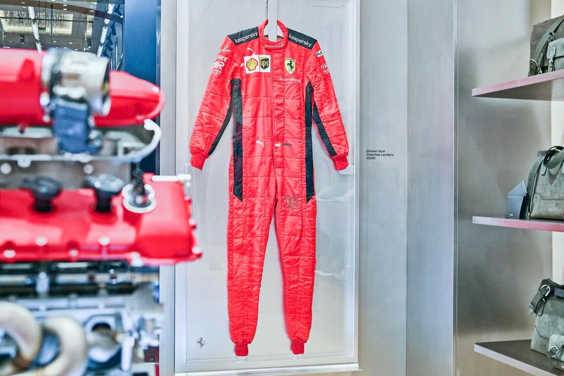 F1 driver Charles Leclerc’s race suit hangs in the Ferrari Lifestyle pop-up at Marina Bay Sands.