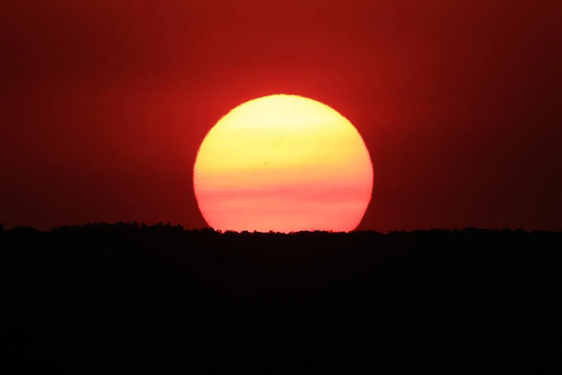 The sun rising, partially obscured by smoke from the Dragon Bravo Fire burning on the North Rim of the Grand Canyon, as seen from Mather Point on the canyon's South Rim, Arizona, US, on July 15, 2025.  