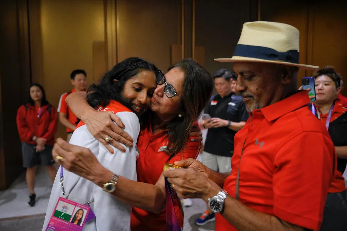 Shanti Pereira celebrating her 200m gold with her parents at the Hangzhou Olympic Sports Centre Stadium.