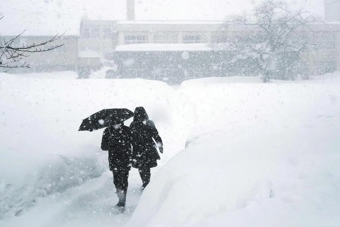 Residents leaving a polling station for Japan's general election in Aomori prefecture on Feb 8. Continued snowfall since late January has buried northern communities and caused traffic chaos.
