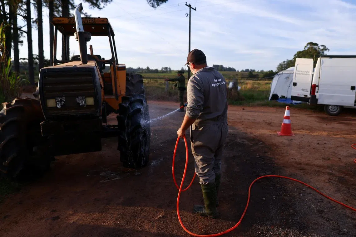 A man cleans a tractor at a sanitary barrier, after Brazil confirmed its first outbreak of bird flu on Friday, triggering protocols for a country-wide trade ban from top buyer China and state-wide restrictions for other major consumers, in Montenegro, Brazil May 17, 2025. REUTERS/Diego Vara