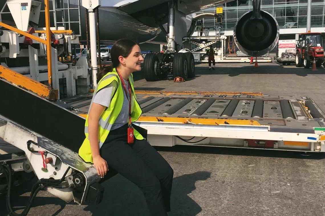 Anastasiia Smyk, CEO of aviation software solutions company Input Soft, sits by an aeroplane at Kyiv's Boryspil International airport, Ukraine, in this undated handout image. Smyk launched her company outside Ukraine in Warsaw, where she worked with a growing Ukrainian refugee tech community.    Valentyn Zavadskyi/Anastasiia Smyk/Handout via REUTERS