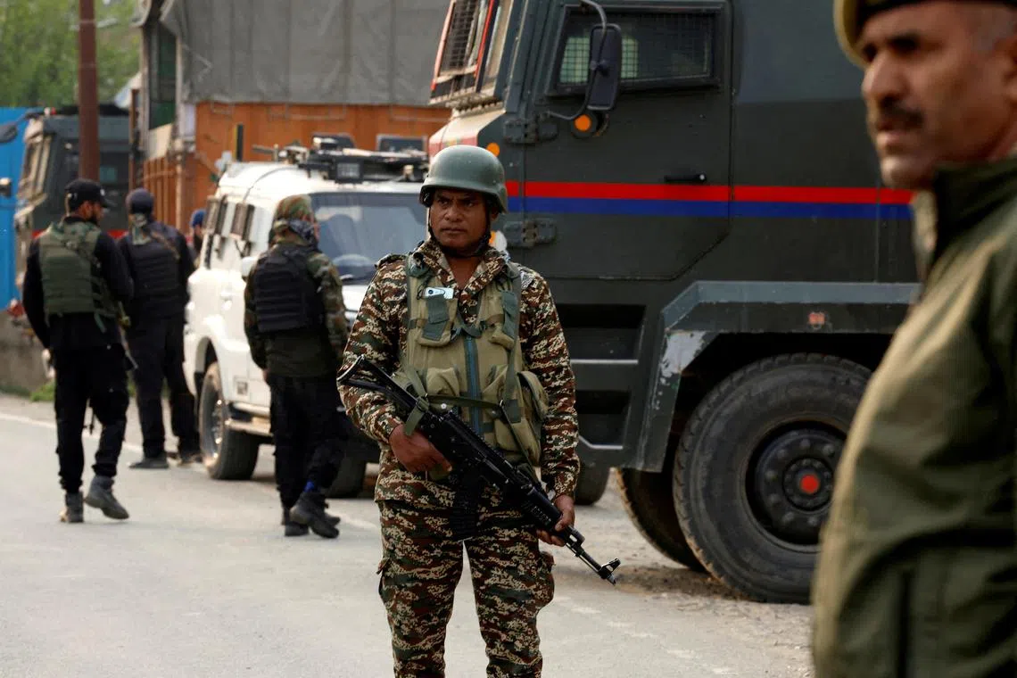 Indian security force personnel stand guard near the site of a fighter jet crash in Wuyan in India-administered Kashmir's Pulwama district on  May 7.