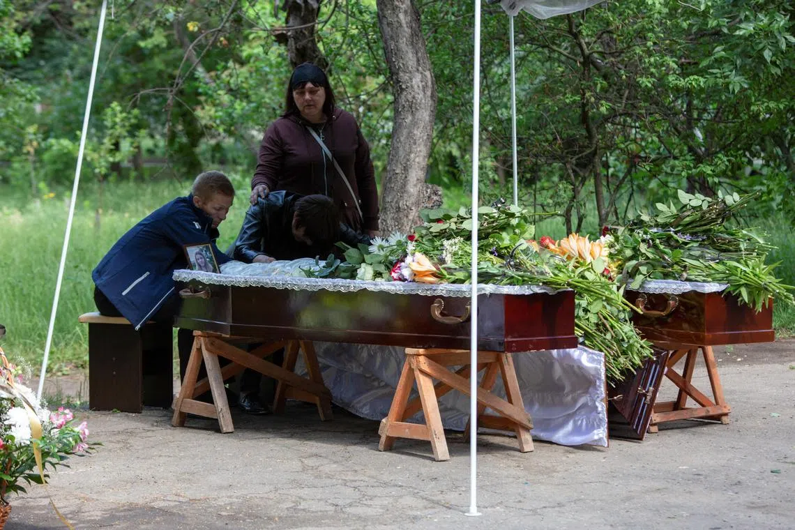 Oleh and Olha Aksenchenko bidding farewell to their 14-year-old twin daughters Anna and Yuliia, who were killed in a restaurant by a Russian missile strike in Kramatorsk, Ukraine, on June 30, 2023. 