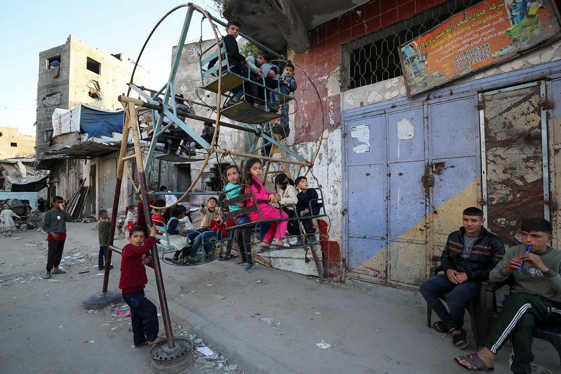 Palestinian children playing on a swing during Eid al-Fitr holiday, in Jabalia, in the northern Gaza Strip, March 30, 2025. 