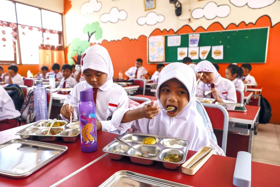 epaselect epa11808277 Schoolchildren have free meals at an elementary school in Depok, West Java, Indonesia, 06 January 2025. The Indonesian government has officially started the Free Nutritious Meal Program (MBG) with a total of 190 kitchens across 26 provinces serving the community, aiming to make a major milestone in fulfilling national nutrition needs.  EPA/MAST IRHAM