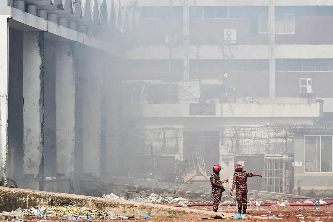 Firefighters inspect as smoke engulfs the fire-damaged cargo terminal of Hazrat Shahjalal International Airport in Dhaka on Oct 19, 2025.