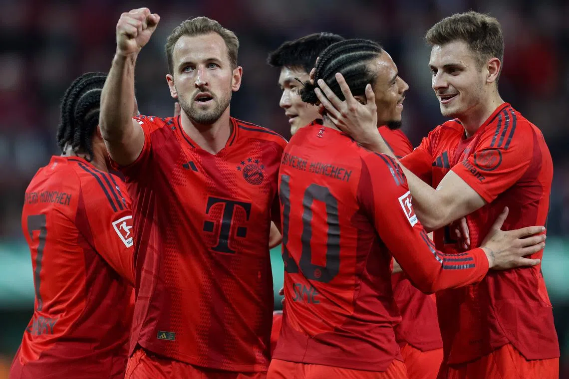 Bayern Munich's Harry Kane celebrates with teammates after scoring against FC Augsburg in a Bundesliga match.