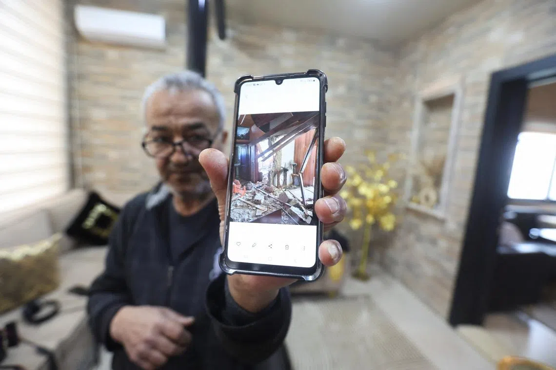 Khiam resident, Hussain Khrais shows a picture on his phone of his home before it was rebuilt after being damaged during the latest hostilities between Israel and Lebanon, in Khiam village, near the border with Israel, southern Lebanon, February 19, 2026. REUTERS/Aziz Taher
