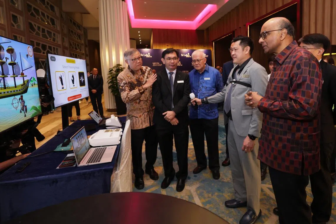 President Tharman Shanmugaratnam watching a demonstration at a robotics rehab therapy booth during St Luke’s ElderCare's SLEC’s 25th Anniversary Gala Dinner.
