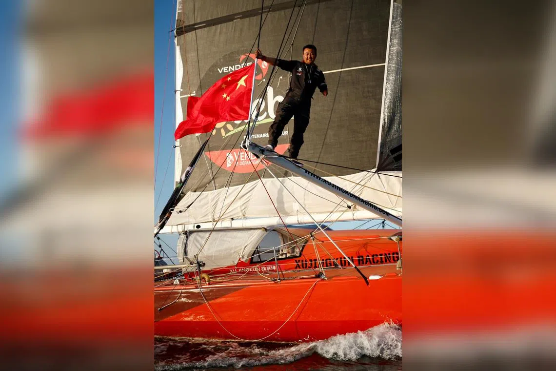 China's skipper and Paralympic athlete Xu Jingkun poses on his IMOCA Singchain Team Haikou during a training session  on Nov 10.