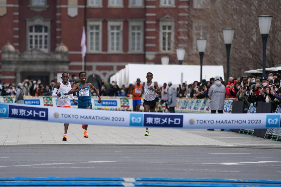 Deso Gelmisa (centre), Mohamed Esa (left) and Getachew Kebede compete during the Tokyo Marathon.