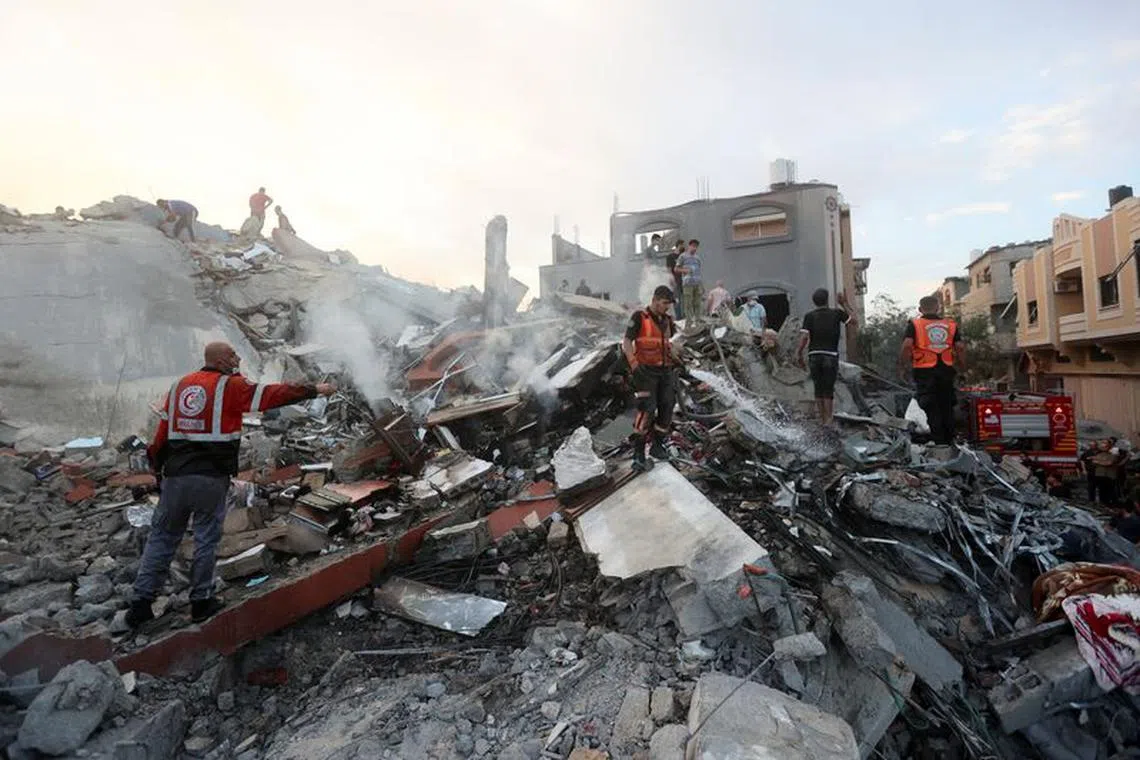 Palestinians conduct search and rescue operations at the site of Israeli strikes on a residential building, in the central Gaza Strip October 31, 2023. REUTERS/Ahmed Zakot