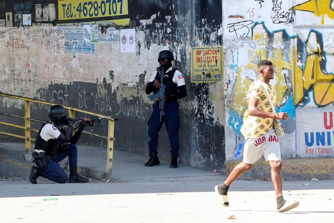 FILE PHOTO: A man rushes past members of security forces during clashes between gangs and security forces, in Port-au-Prince, Haiti November 11, 2024. REUTERS/Marckinson Pierre/File Photo