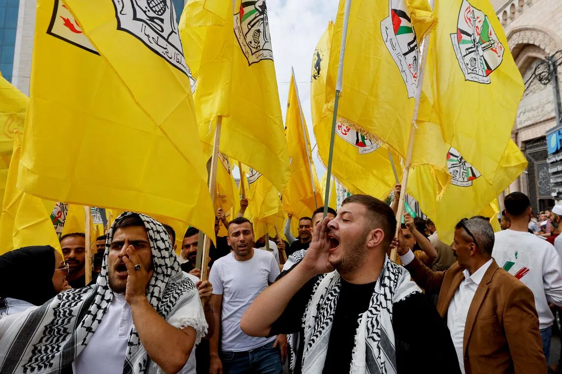 FILE PHOTO: People hold Fatah flags during a protest in support of the people of Gaza, as the conflict between Israel and Palestinian Islamist group Hamas continues, in Hebron, in the Israeli-occupied West Bank, October 27, 2023. REUTERS/Mussa Qawasma/File Photo
