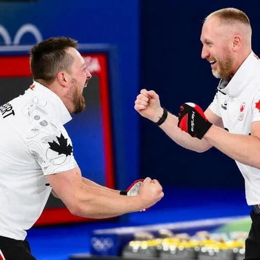 Canada's Ben Hebert (left) and Brad Jacobs celebrate becoming Olympic Champions after defeating team GB in the curling men's gold medal game on Feb 21, 2026.