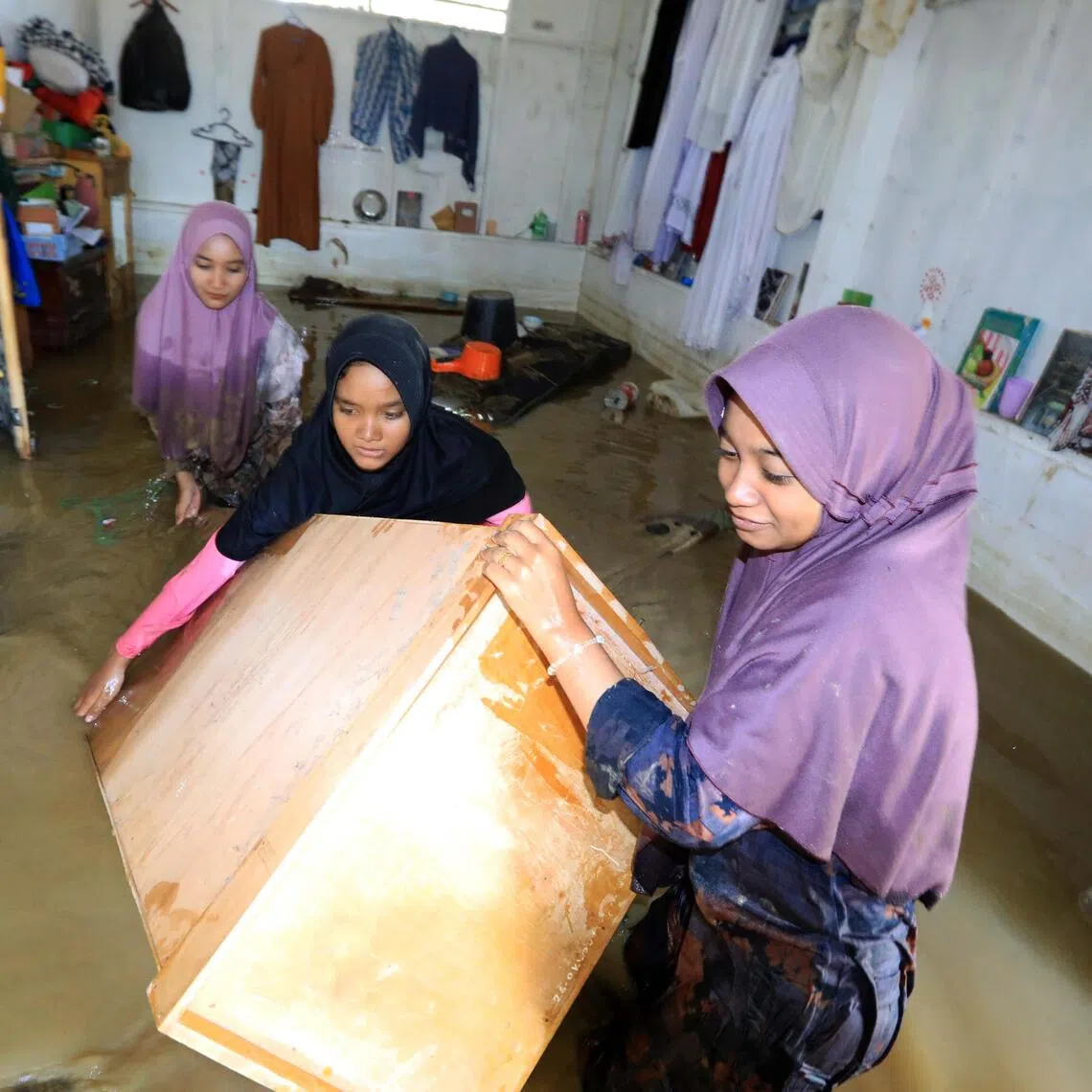 A group of women tries to salvage what is left of their belongings from their home in Aceh, Indonesia.
