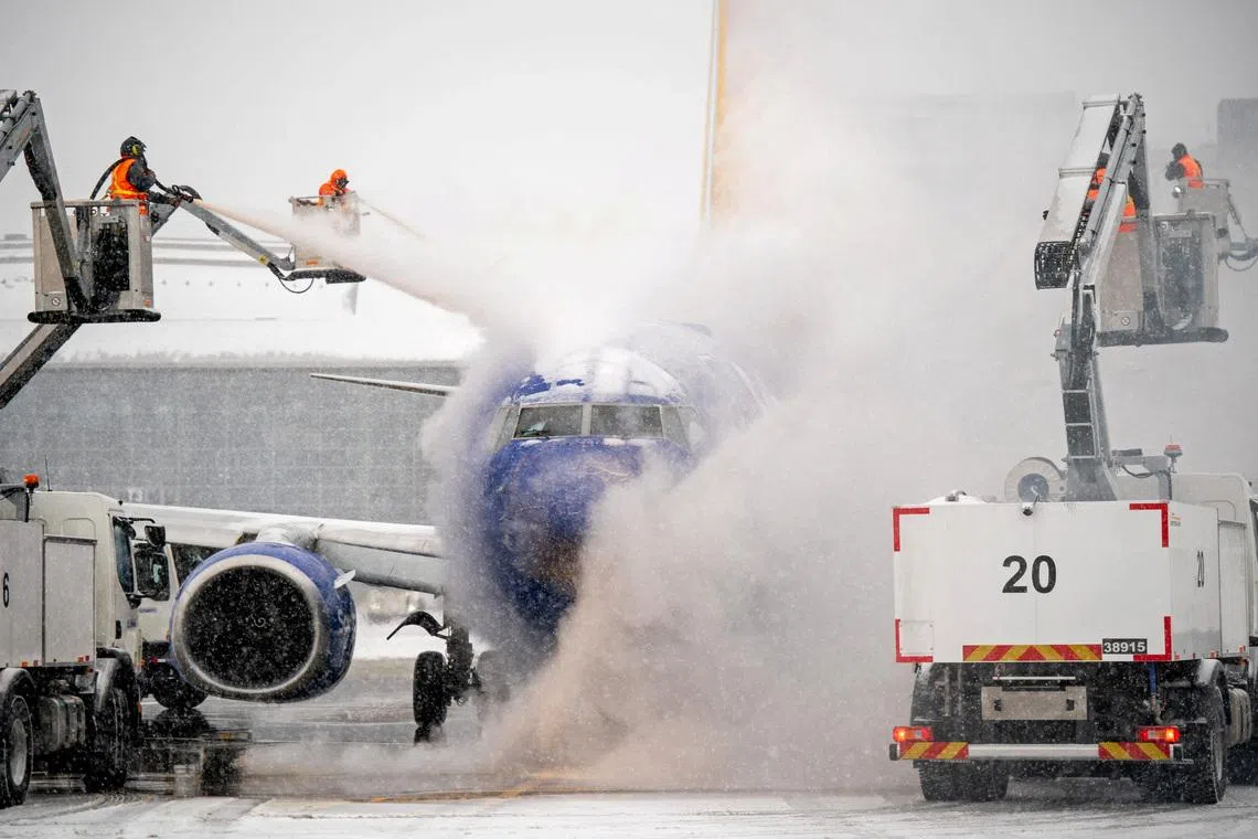 A de-icing crew works during winter storm Fern on a Southwest Airlines flight at Nashville International Airport in Nashville, Tennessee, U.S. on Jan 24, 2026.  Andrew Nelles/USA Today Network via REUTERS    NO 