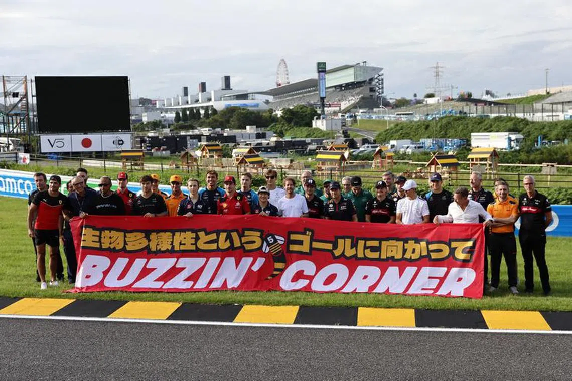 Formula One F1 - Japanese Grand Prix - Suzuka Circuit, Suzuka, Japan - September 21, 2023 Former driver Sebastian Vettel poses with drivers and team members as he launches 'Buzzin' Corner' a project to raise awareness about the importance of biodiversity REUTERS/Issei Kato