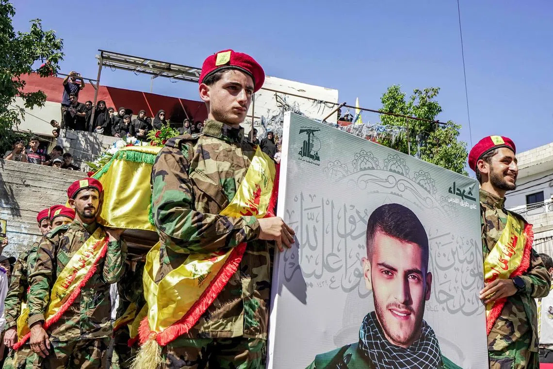 Fighters of the Lebanese Shi'ite movement Hezbollah attend the funeral of their fallen comrade who was killed in an Israeli bombardment on a village in south Lebanon on Aug 23.