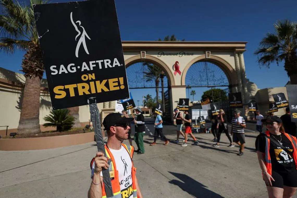 Team captain Spencer Morgan holds a placard as he and other SAG-AFTRA members walk the picket line on the 100th day of their ongoing strike, outside Paramount Studios in Los Angeles, California, U.S., October 20, 2023. REUTERS/Mario Anzuoni