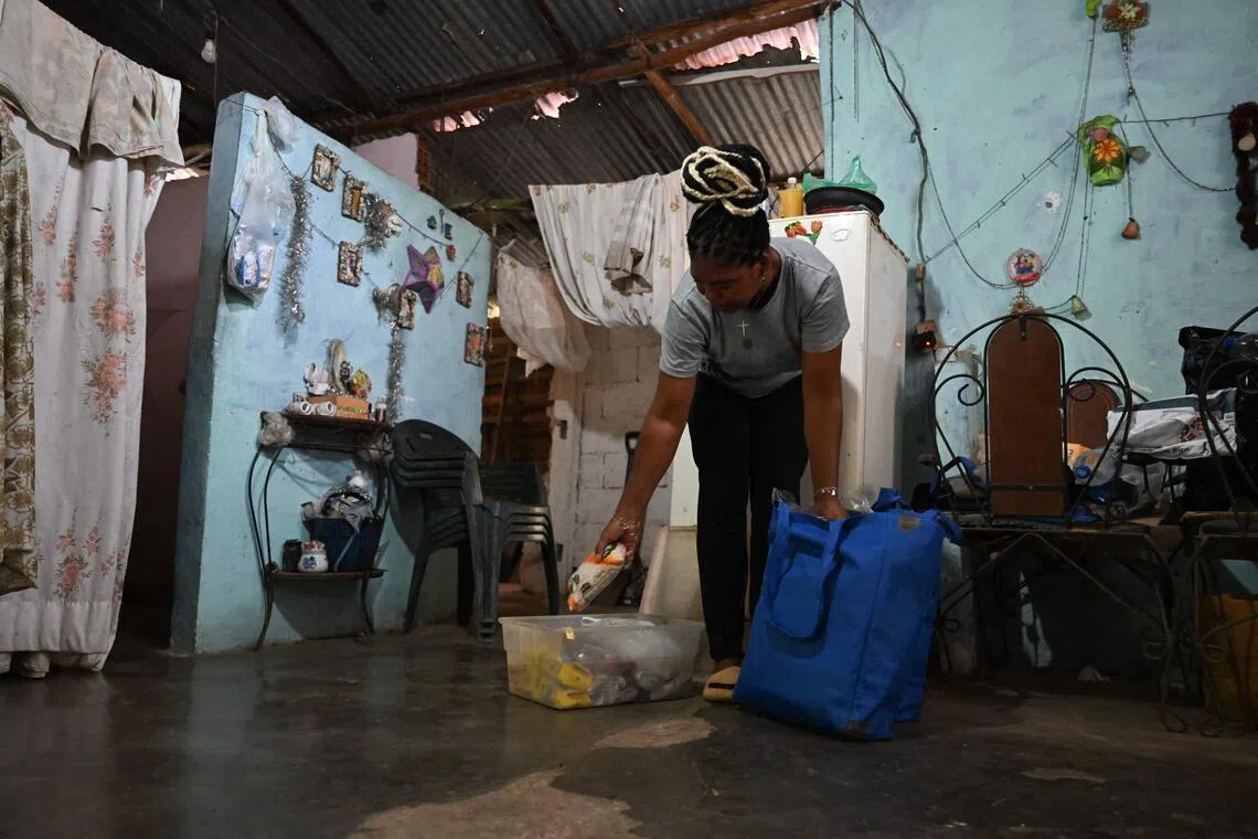 Leida Bello unpacks a bag of food donated by the World Food Programme (WFP) in her home in Chichiriviche de la Costa, La Guaira state, Venezuela, on July 16, following the June 24 earthquakes.