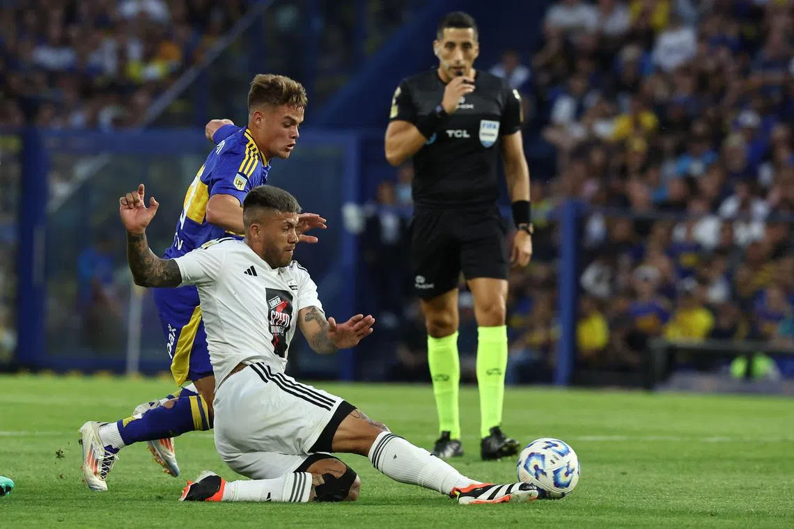 Deportivo Riestra's forward Milton Celiz (No. 8) and Boca Juniors' midfielder Ignacio Miramon tussling for the ball during the Argentine Professional Football League Tournament.