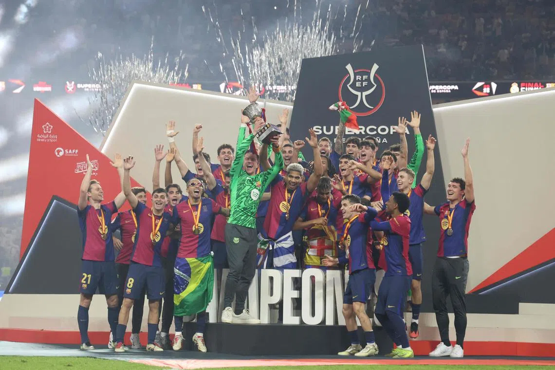 Barcelona players celebrating with the trophy after winning the Spanish Super Cup.