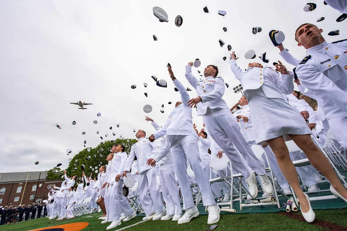 Newly commissioned officers tossing their hats during the US Coast Guard Academy’s 144th Commencement in New London, Connecticut, on May 21, 2025.