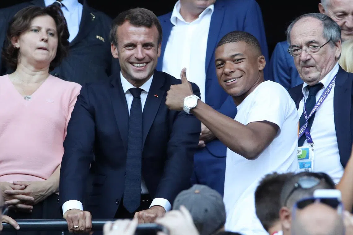FILE PHOTO: Soccer Football - Women's World Cup Final - United States v Netherlands - Groupama Stadium, Lyon, France - July 7, 2019 French President Emmanuel Macron in the stands with Kylian Mbappe before the match REUTERS/Denis Balibouse/File Photo