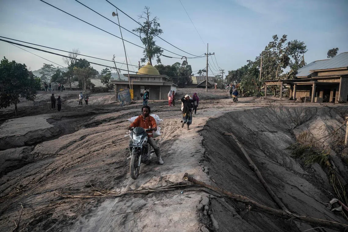 People salvage their belongings following a volcanic eruption by Mount Semeru at Kajar Kuning village in Lumajang, on Dec 5, 2022. 