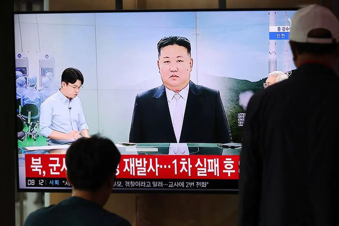 FILE PHOTO: Passengers watch a TV broadcasting a news report on North Korea firing a space rocket, at a railway station in Seoul, South Korea, August 24, 2023.    REUTERS/Kim Hong-Ji/File photo