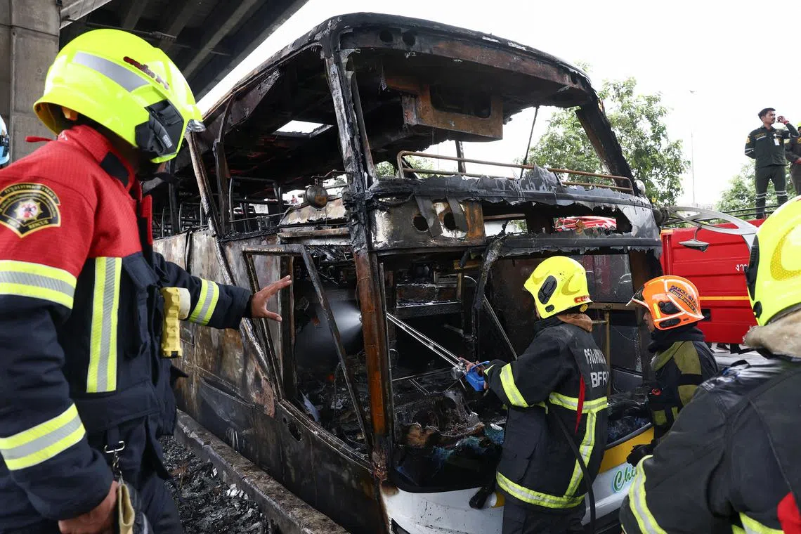 Firefighters work to extinguish a burning bus that was carrying teachers and students from Wat Khao Phraya school, reportedly killing almost a dozen, on the outskirts of Bangkok, Thailand, October 1, 2024. REUTERS/Chalinee Thirasupa