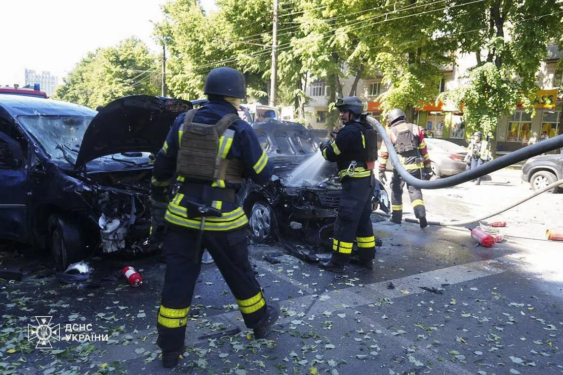 Ukrainian emergency crews working at the site of a Russian artillery strike in downtown Sumy, northeastern Ukraine, on June 3.