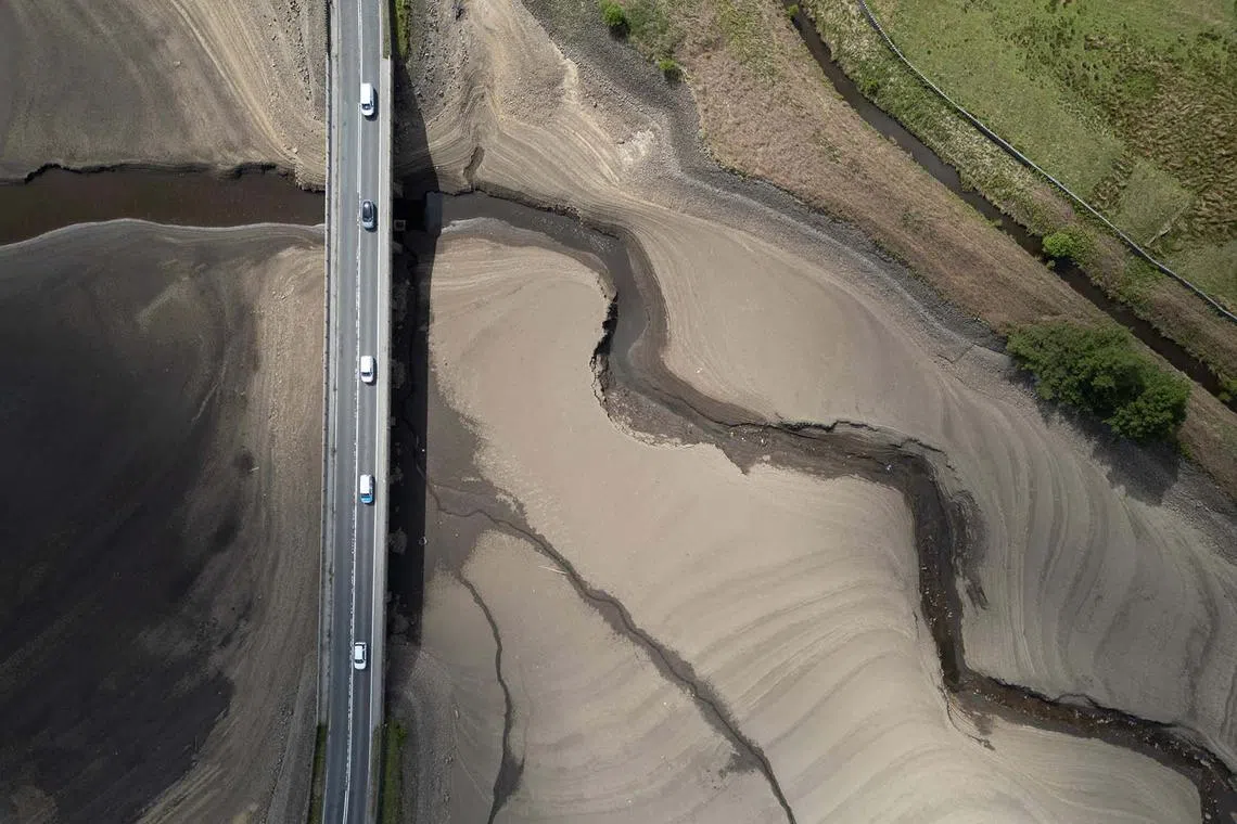 Woodhead Reservoir is partially revealed by its receding water level, near Glossop, northern England on May 22, 2025. Data from United Utilities, the United Kingdom's largest listed water company, shows that reservoir levels for the north west of England stands at 61.9% of capacity, down from 88.8% at the same period in 2024. 