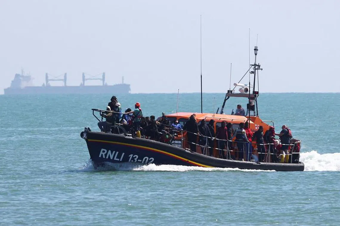 FILE PHOTO: People, believed to be migrants, arrive on a lifeboat in Dungeness, Britain, August 16, 2023. REUTERS/Toby Melville/File Photo