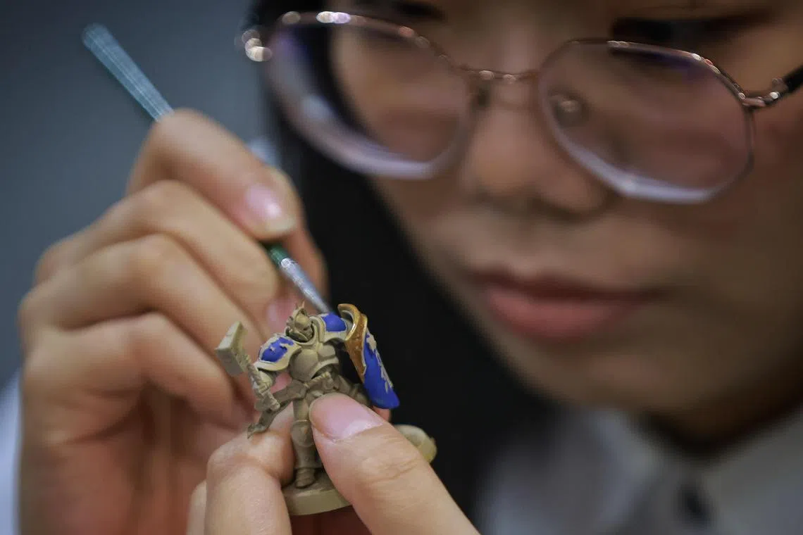 An artist painting a miniature figurine during Singapore Comic Con at the Sands Expo & Convention Centre on Sunday (Dec 11, 2022). 