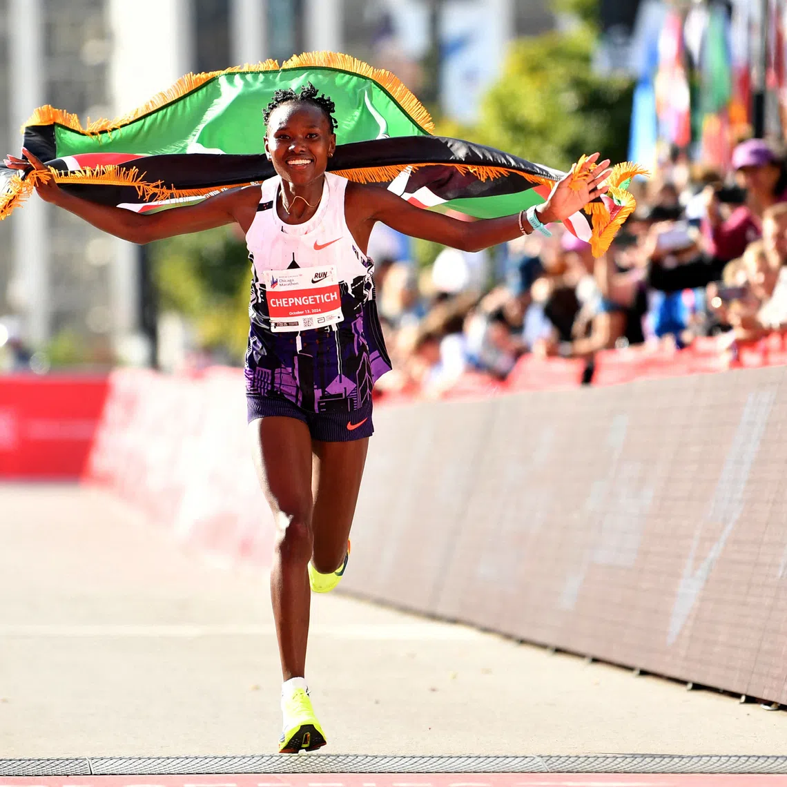 Oct 13, 2024; Chicago, IL, USA; Ruth Chepngetich of Kenya celebrates after finishing first in the women’s race, setting a new world record at 2:09:56 during the Chicago Marathon at Grant Park. Mandatory Credit: Patrick Gorski-Imagn Images