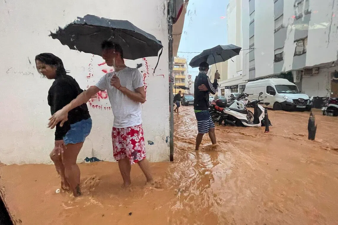epa12416591 People walk along flooded streets in Ibiza, Spain, 30 September 2025, after heavy rains that have caused several floods throughout the island. Spain's State Meteorological Agency (Aemet) issued red, orange and yellow alerts for heavy rains affecting several regions across the country.  EPA/Sergio G. Canizares
