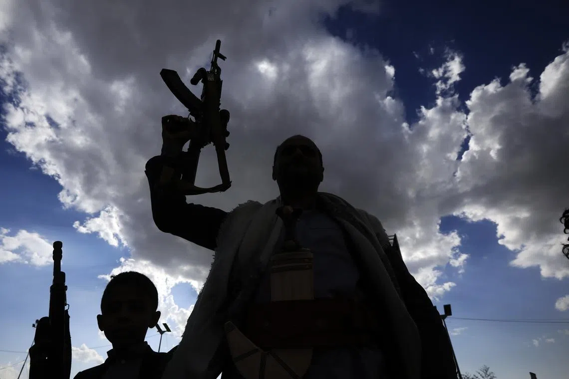 A Houthi supporter holding up his weapon during a protest in Sana'a, Yemen, on Mar 17, 2025 against US airstrikes on Houthi positions. 