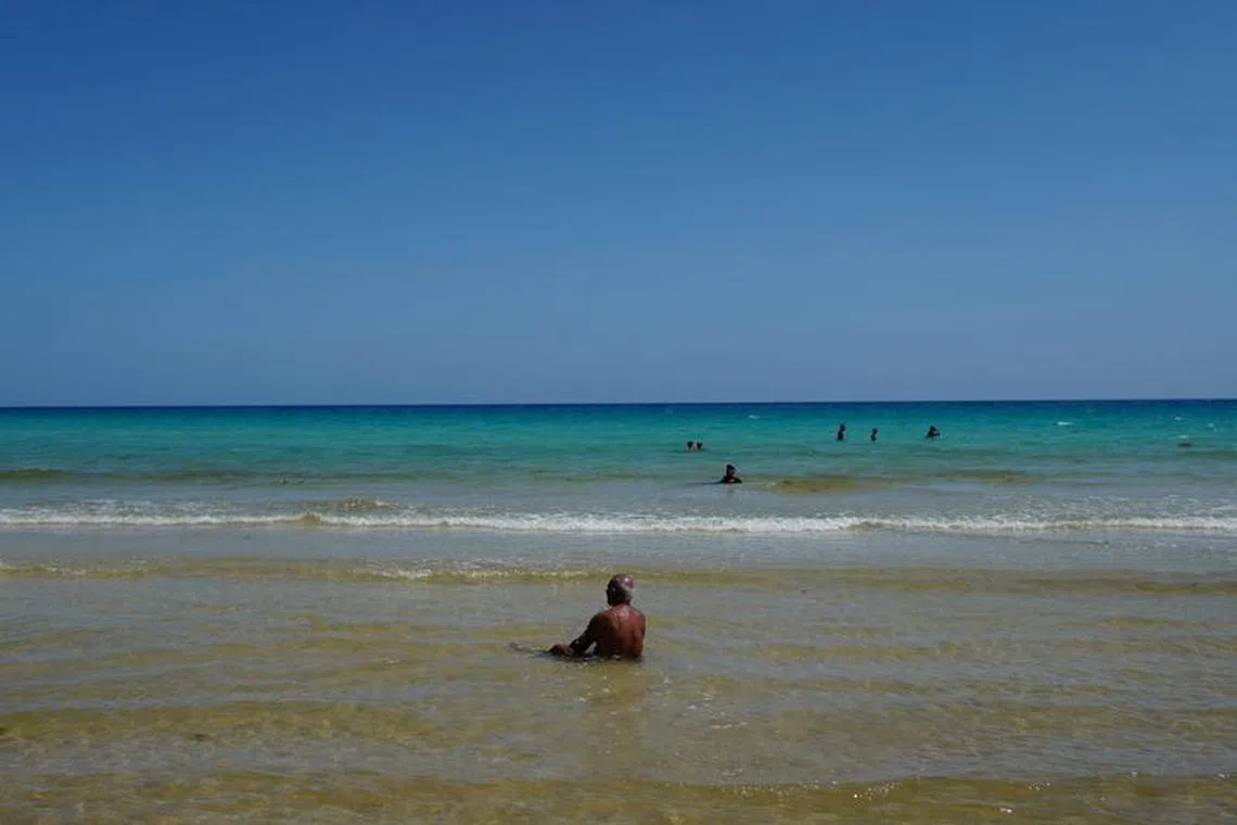 FILE PHOTO: People enjoy the beach in Havana, Cuba, August 9, 2023. REUTERS/Alexandre Meneghini/File Photo