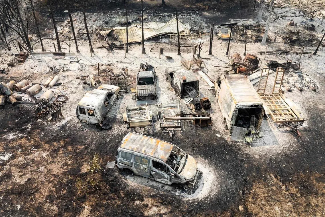 TOPSHOT - This aerial view shows burnt cars following a wildfire in Le Porge, in the Gironde Department, south-western France on July 25, 2026. The fires, which are on an unprecedented scale and have forced the evacuation of around 200,000 "fire refugees" in Gironde and the Landes, were still not under control on July 25, 2026 and continue to keep firefighters and military personnel on high alert, including an A400M aircraft deployed to tackle the blaze for the first time. (Photo by Florian PLAUCHEUR / AFP)