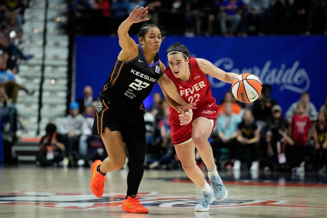 Caitlin Clark (right) of the Indiana Fever drives on Veronica Burton of the Connecticut Sun during the fourth quarter of Game 2 of the 2024 WNBA play-offs on Sept 25. The Sun won 87-81 at the Mohegan Sun Arena in Uncasville, Connecticut, to clinch the series 2-0 and a semi-final spot.
