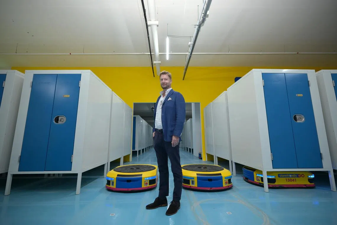 jlstore/ST20241216_202414400676/Ng Sor Luan/ Storefriendly CEO Jes Johansen with the company's robots which are able to move storage units to terminals where users can access them.