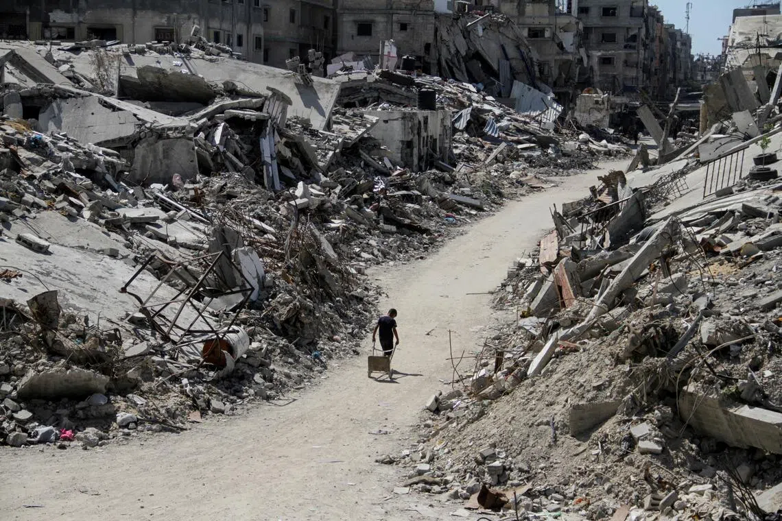 A Palestinian walks among the rubble of damaged buildings, which were destroyed during Israel's military offensive, amid the ongoing conflict between Israel and Hamas, in Beit Lahia in the northern Gaza Strip, June 12, 2024. REUTERS/Mahmoud Issa