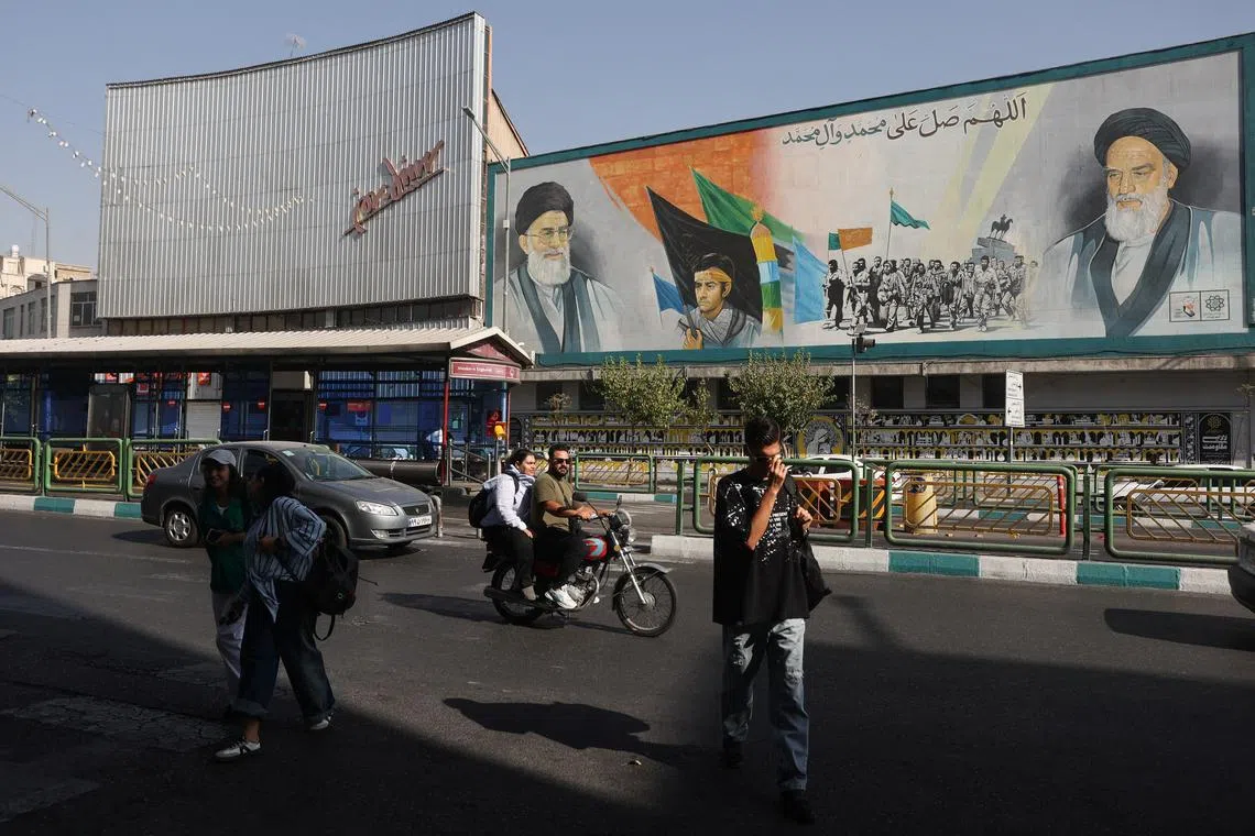 People walk past a mural with a picture of Iran's Supreme Leader, Ayatollah Ali Khamenei, on a street in Tehran, Iran August 29, 2025. Majid Asgaripour/WANA (West Asia News Agency) via REUTERS