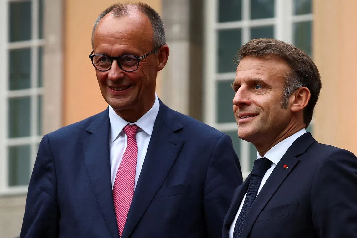 FILE PHOTO: German Chancellor Friedrich Merz stands next to French President Emmanuel Macron as he welcomes him for bilateral talks at Villa Borsig in Berlin, Germany July 23, 2025. REUTERS/Lisi Niesner/File Photo