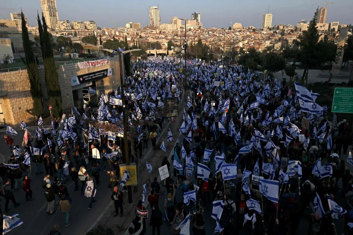 People march with Israeli flags during a protest against the government's judicial reform bill near the Knesset (parliament) in Jerusalem on Feb 20.